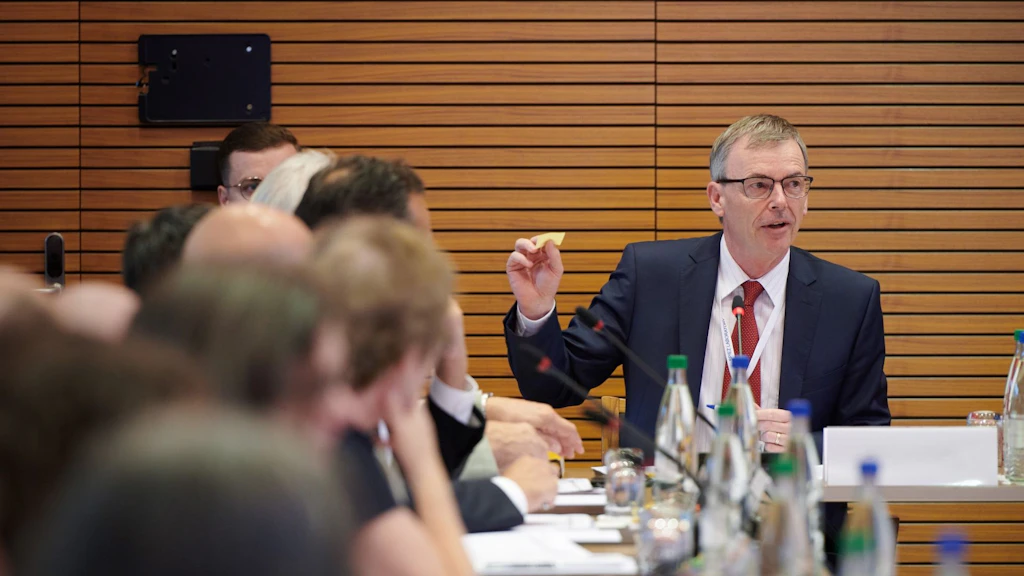 Mehrere Personen hocken an einem u-förmigen Tisch während der CONVERGENCE Konferenz 2024 